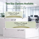 Personalized desk tissue boxes shown in two sizes on white display blocks, with text indicating size options and printed names such as Mari Estrada, Project Manager. The background is a softly blurred office interior.